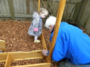 Hadley carefully studying what Grandpa is doing so that she can do it on her own