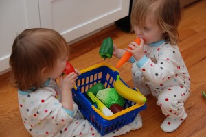 Hadley and Lydia tasting their vegetables for freshness