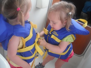 Lydia helping Hadley fasten her life jacket